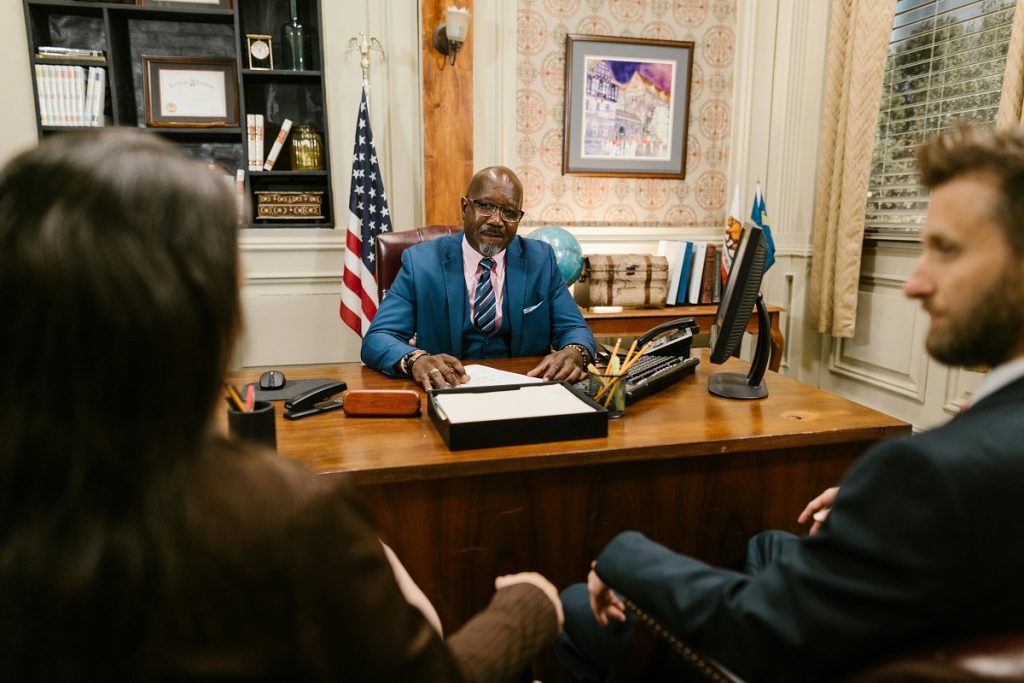 experienced divorce lawyer sitting at a desk, talking to a couple