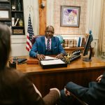 experienced divorce lawyer sitting at a desk, talking to a couple