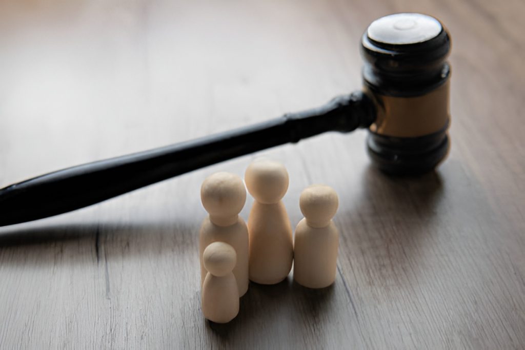 wooden gavel and four wooden figurines representing a family