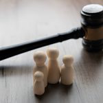 wooden gavel and four wooden figurines representing a family